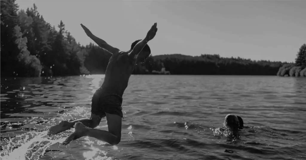 kid jumping out of boat